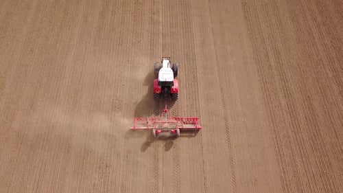 Tractor Plows Field From Overhead Aerial Shot