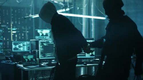 Officer Escorting Hooded Suspect in Dark Server Room