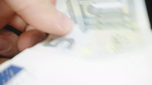The camera moves along the brown jeans as I put a five euro banknote into their pocket. Macro slider
