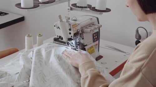 Female Tailor Working at Sewing Machine in Workshop