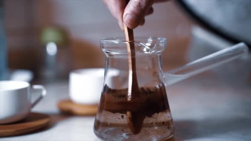 Boiling Turkish coffee, close up, modern look. Process of making coffee at home . Woman make coffee