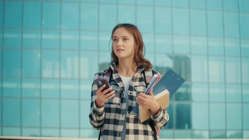 Pretty Student Girl Using a Smartphone on Background of Campus