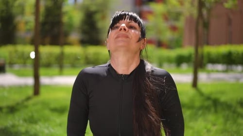 A Woman in a Tracksuit Performs a Child's Pose During Yoga Exercises A Woman Performs a Fitness