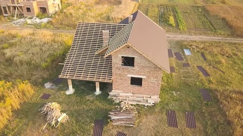 Aerial View of Unfinished House with Wooden Roof Structure Covered with Metal Tile Sheets Under
