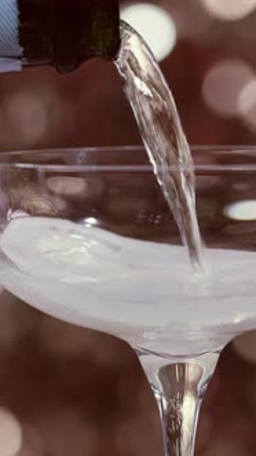 Champagne Being Poured in a Tall Glass