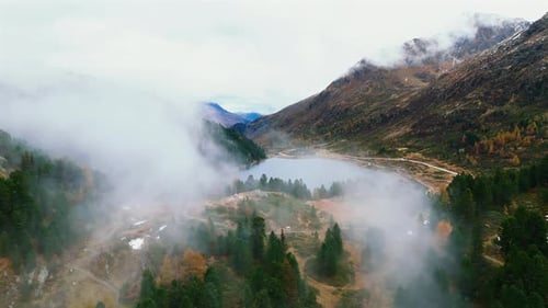 Nuages enveloppant le lac Obersee dans la vallée alpine de Staller Sattel