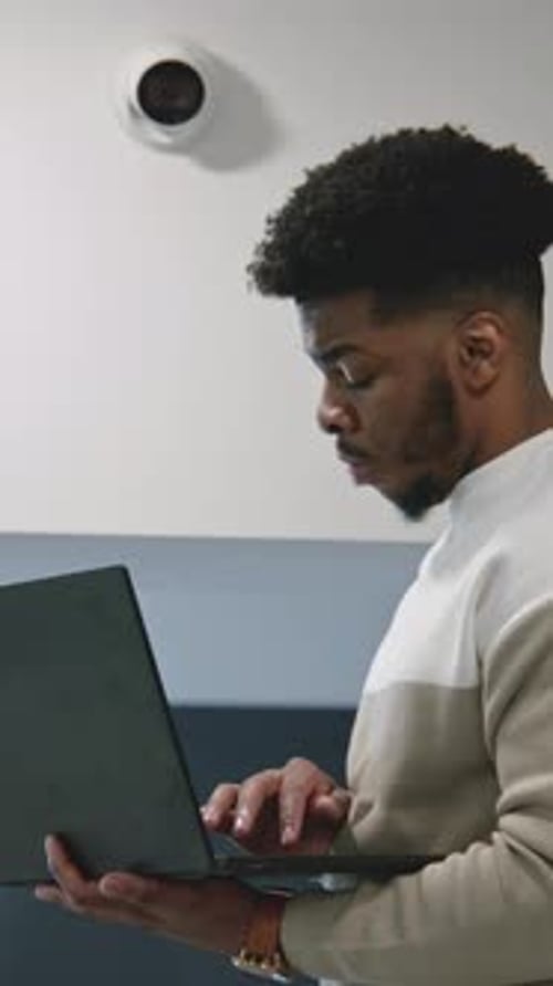 African American Installer Sets Up Security Camera in Office