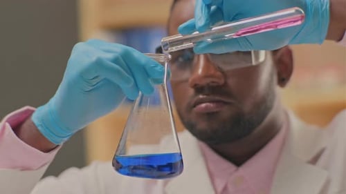 Scientist Mixes Colorful Liquids in Glassware
