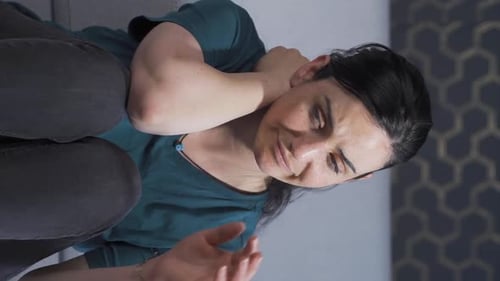Woman Experiencing Neck Pain and Sadness Indoors