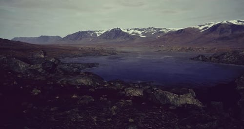 Majestic Mountain Landscape with a Serene Lake Under a Cloudy Sky