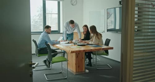 A Team of Young People Working in a Company Together in a Modern Office Sitting at a Negotiating