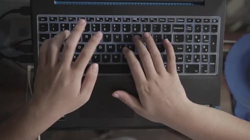 Man's Hands Typing on Laptop With Fingers Running on Keyboard, Top View