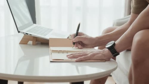 Hands of Male Employee Organizing Work and Making Notes by Workplace at Home