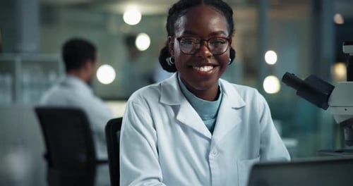 Smiling Scientist in Lab Coat with Microscope