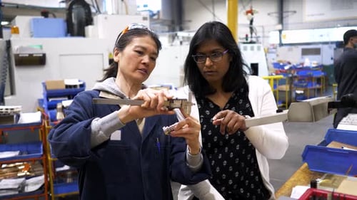 Female Worker and Manager Using Calipers in Manufacturing Plant 3539 Years