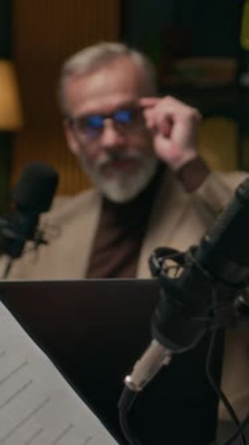 Female Podcast Host Analyzing Script when Talking to Mature Man in Studio