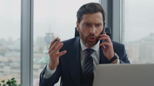 Furious ceo shouting on cellphone in luxury office receiving bad financial report