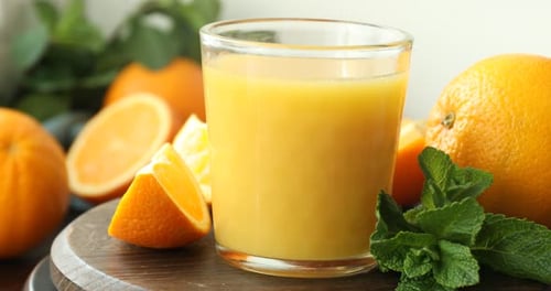 Fresh Orange Juice and Oranges on Table