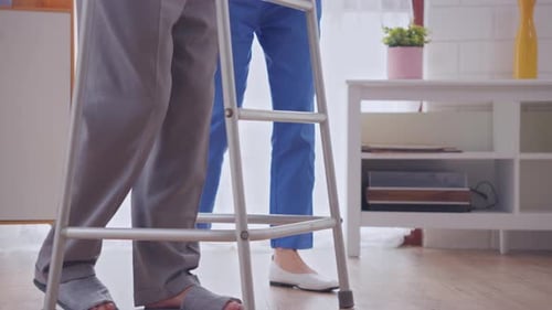 Close up feet of male patient doing physical therapy with caregiver.