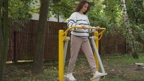 Woman Exercising on Air Walker Machine Outdoor Fitness Gym Equipment in Park