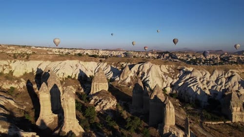 Aerial View of Hot Air Balloons and Chimney Rock Formations in Cappadocia Turkey on Sunny Morning, D