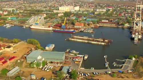 Vista aérea del puerto fluvial en una pequeña ciudad de Asia/Toma aérea de la región industrial de una pequeña ciudad/helicóptero...