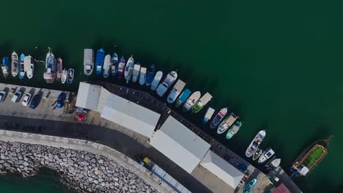 Aerial Video of a Cozy Harbor With White Yachts and Small Fishing Boats Resting on Clear Blue Waters