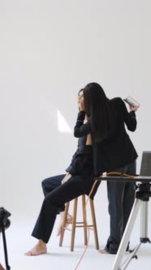 Makeup Artist Applying Cosmetics to Model in Studio