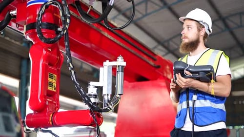 Gemischtrassige Ingenieure, die in einer Roboterfabrik arbeiten - Konzept der Technologiebranche