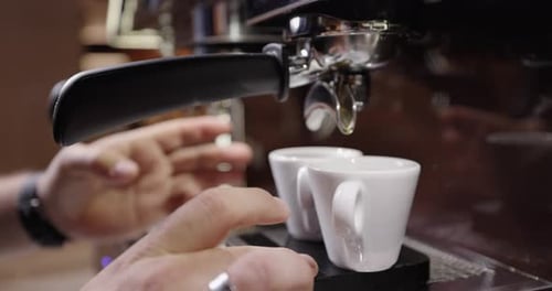Close Up of Espresso Pouring into Two Cups