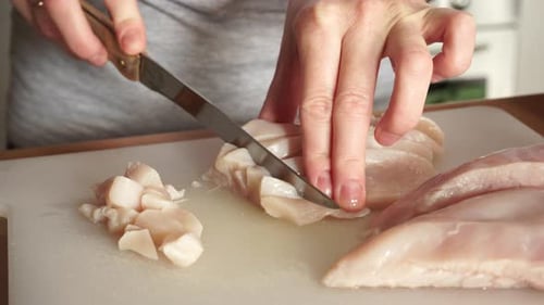 Hands Cutting Raw Chicken Meat