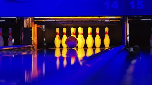 Bowling Strike trifft in Dramatisch Zeitlupe mit Reflexionen von Neonlichtern auf Kegel