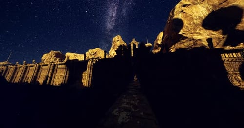 Night Sky Filled with Stars Above Ancient Stone Structure in a Mountainous Area