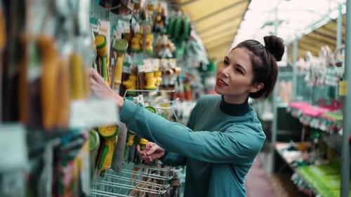 Young Caucasian Woman in Casual Clothes Doing Shopping in Flower Department