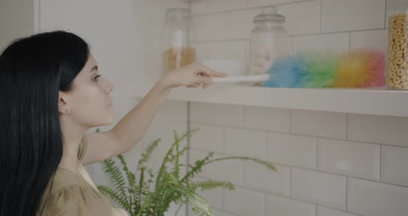 Slow Motion Portrait of Young Lady Dusting Shelf in Kitchen ...