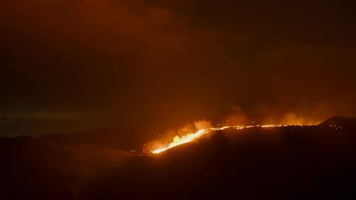 Bright glowing hot lava flowing through the landscape at night -Wide