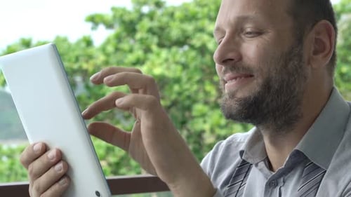 Young Businessman Browsing Internet on Tablet Sitting on Terrace 30s