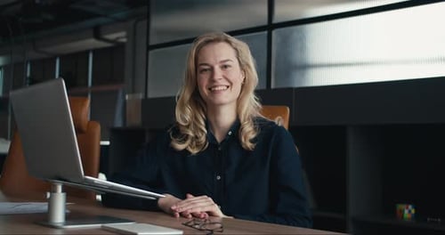 Radiant Blonde in the Blue Realm Embracing Professionalism and Joyful Engagement in the Office