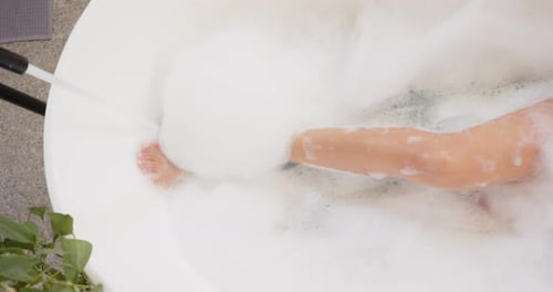 Young Woman Relaxing in Foamy Bubble Bath