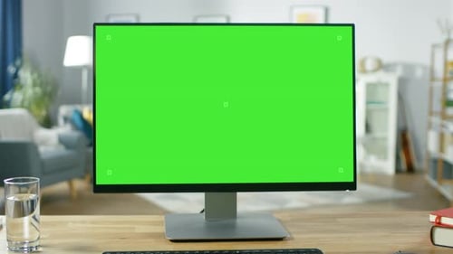 Modern Personal Computer with Green Mock-up Screen Display Standing on the Desk in the Cozy Living