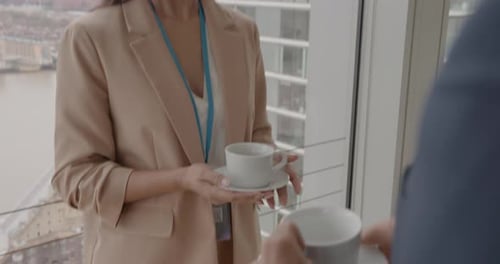 Businesswoman Offers Coffee, Shakes Hands With Businessman