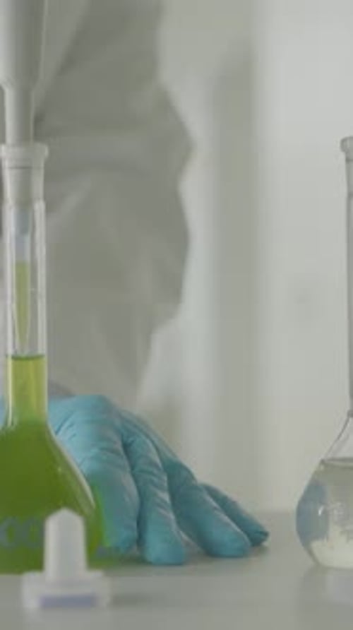 Lab Technician Working with Chemical Solutions in Beakers