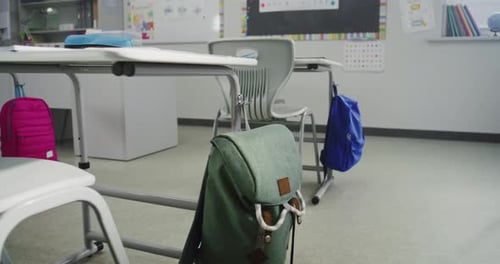 Modern Empty Classroom with Desks School Supplies for Students Hanging Backpacks