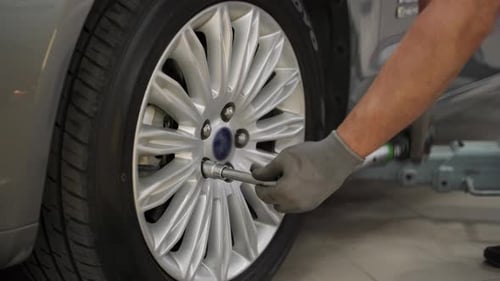 Mechanic Tightens Lug Nuts on Car Tire