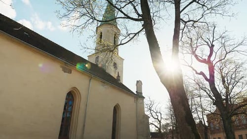 Mittelalterliche Architekturkirche mit Glockenturmbaum davor