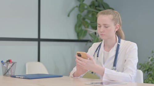 Female Doctor Using Smartphone in Clinic