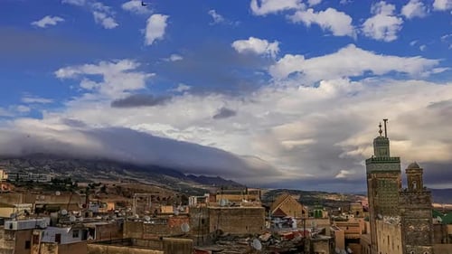 White cloud movement in timelapse over the Koutoubia Mosque and Jemaa el Fna square, Morocco on a br