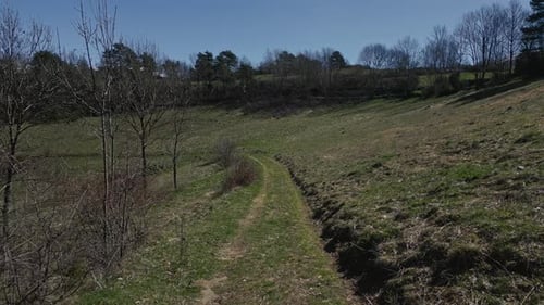 Winding path through green fields under blue sky