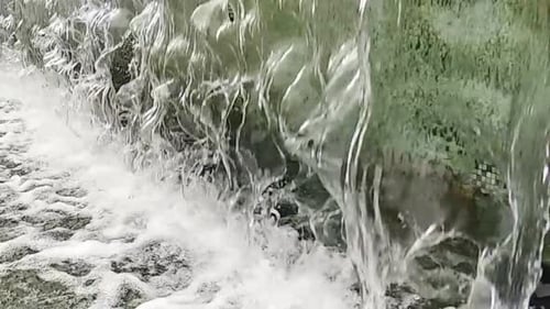 A
água cai de perto ou da fonte para uma pequena piscina na cidade. Câmera lenta