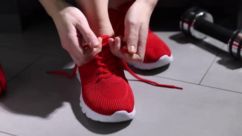 Tying Red Athletic Shoe Laces Before Workout